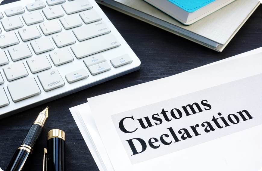 税関書類とペンが並ぶ通関手続きのイメージ